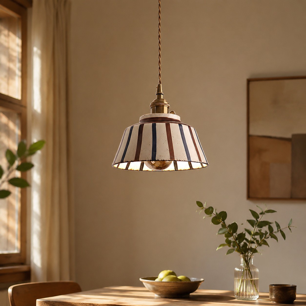 Striped ceramic pendant light over a small dining table
