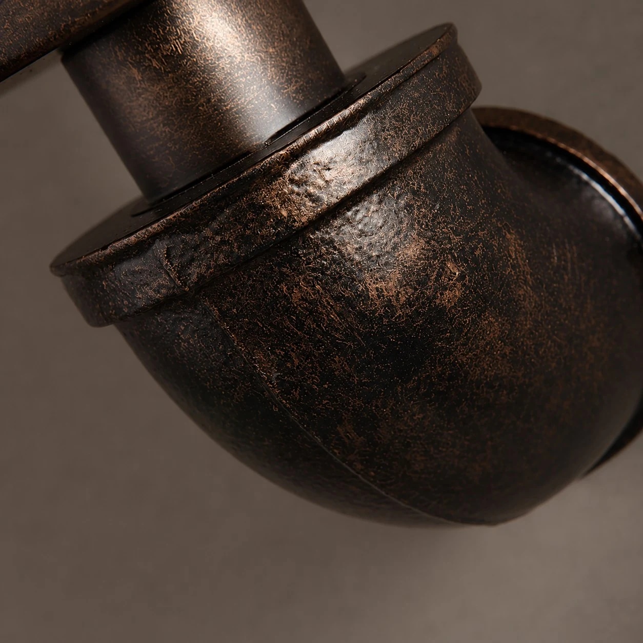 Close view of the rust-toned iron elbow and textured finish