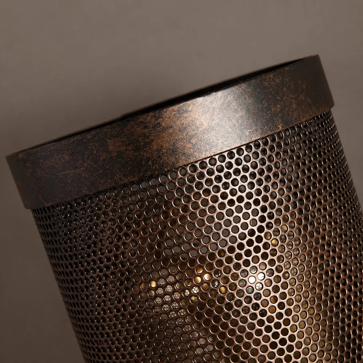 Warm bulb glow visible through the perforated metal shade